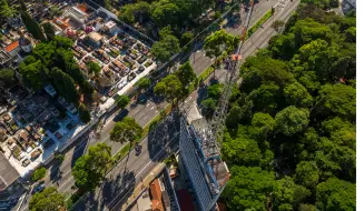 Vista aérea de Pinheiros mostra avenida arborizada, prédios residenciais e ampla área verde urbana paulistana.