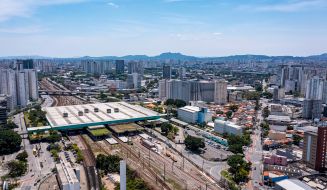 Vista aérea da Barra Funda, bairro em São Paulo, com uma grande avenida, prédios e carros passando.