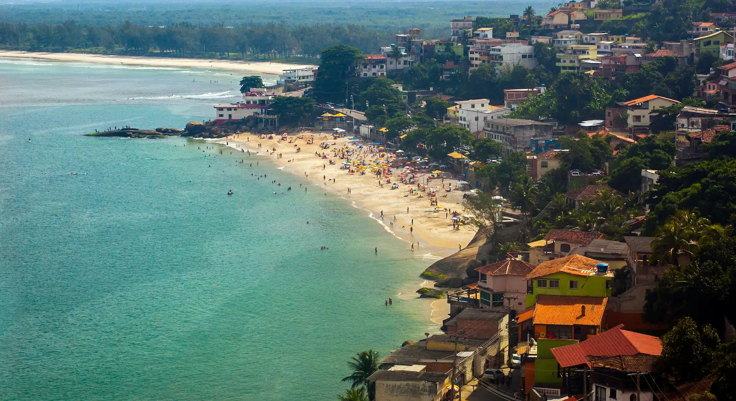 Vista aérea da barra de Guaratiba no Rio de Janeiro, com o mar, pessoas na praia e algumas casas