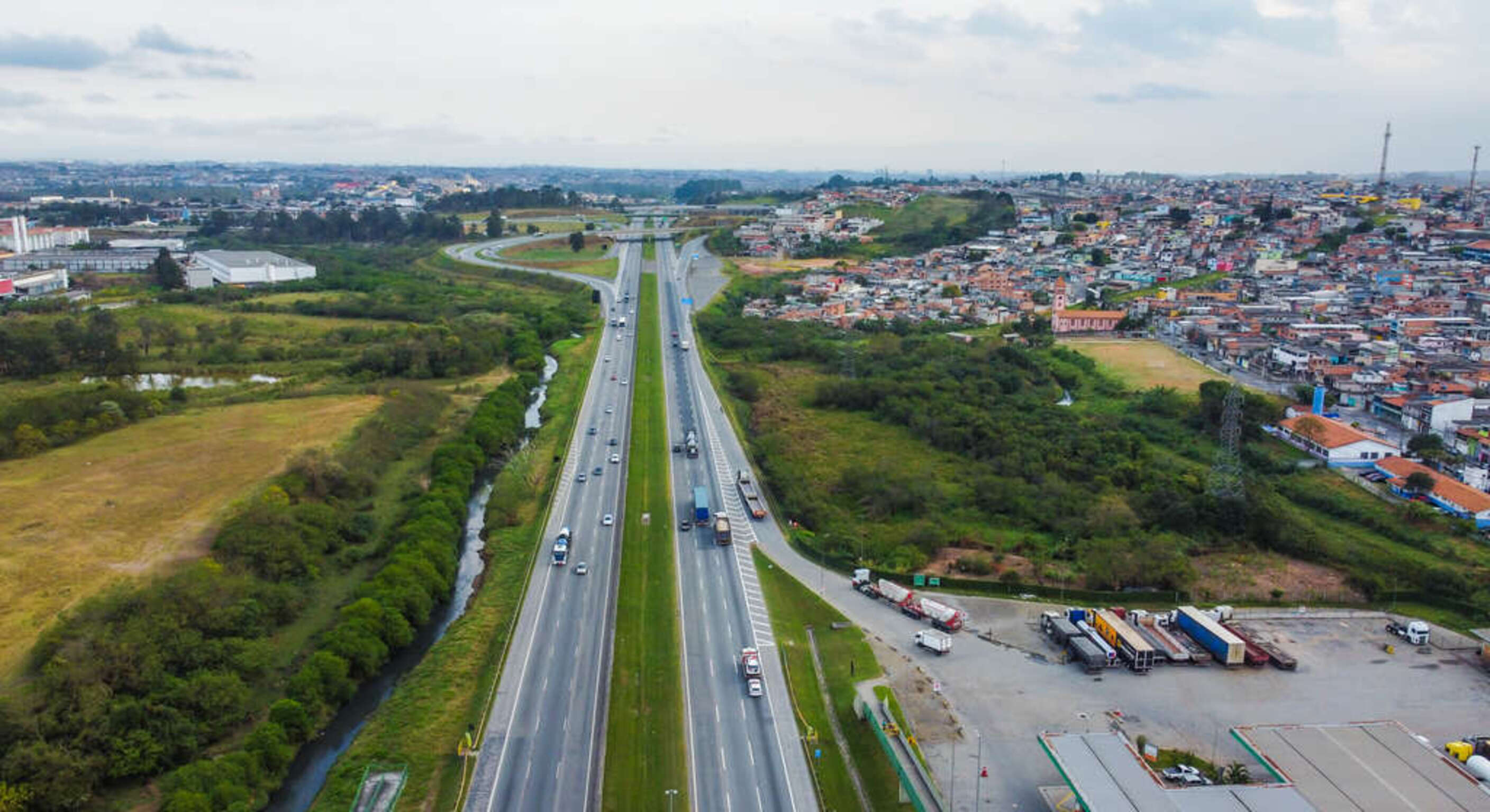 Itaquaquecetuba vista de uma grande avenida e um espaço bem arborizado.