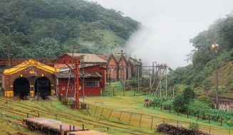 Vista da vila ferroviária histórica, no meio de um morro muito arborizado.
