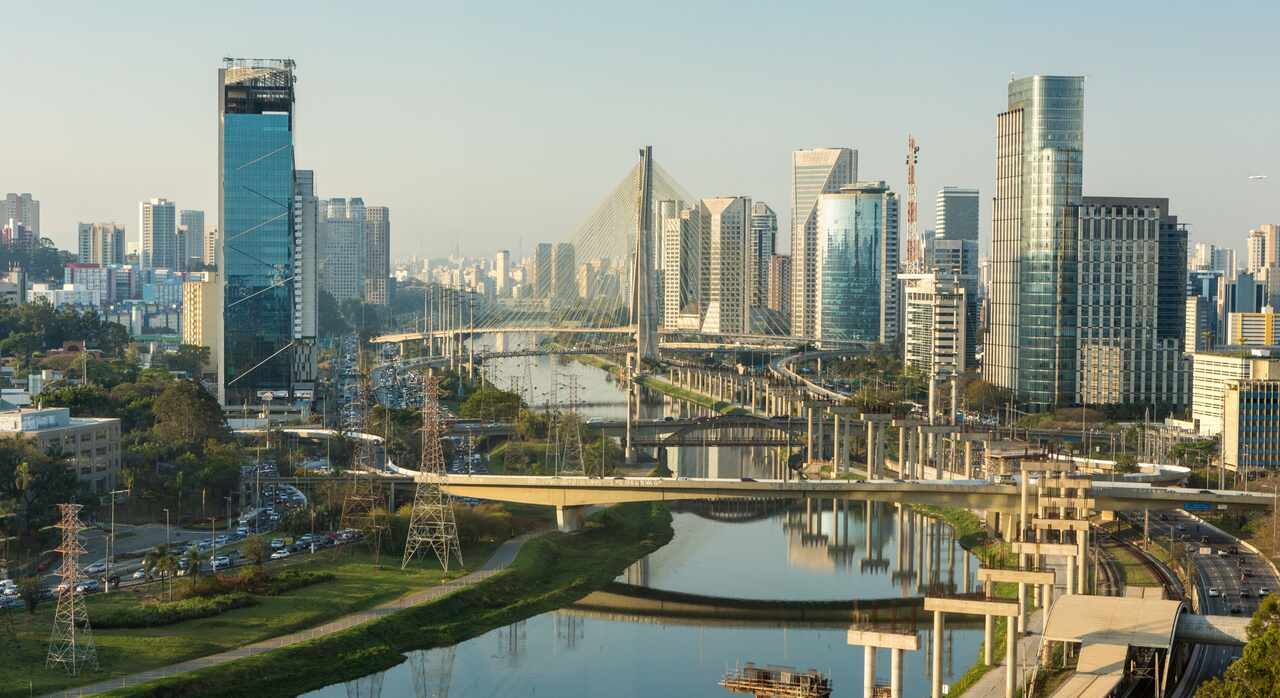 Vista aérea da ponte de São Paulo, com uma grande avenida, prédios e carros passando.