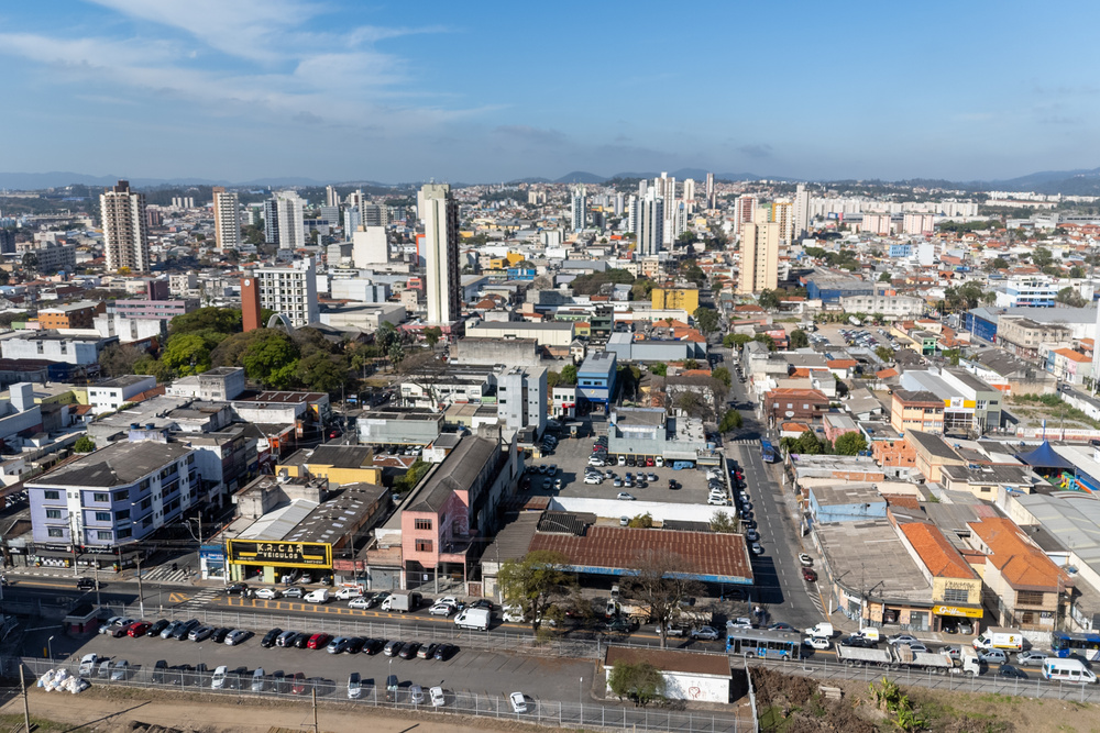 Imagem aérea de Suzano, mostrando uma pequena área comercial com prédios no fundo